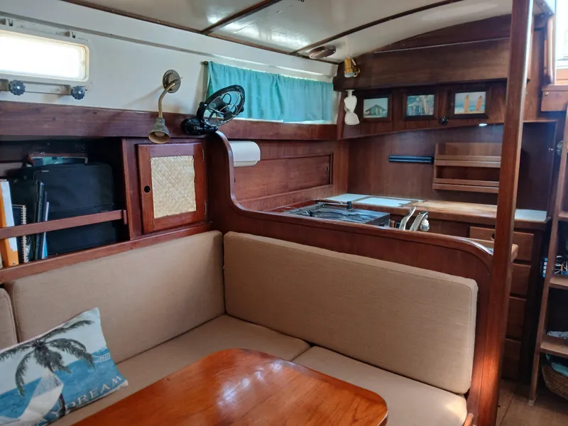 Slide: The Image of Interior of a 1977 Dickerson 41 sailboat with cozy seating and wooden cabinetry. - 12