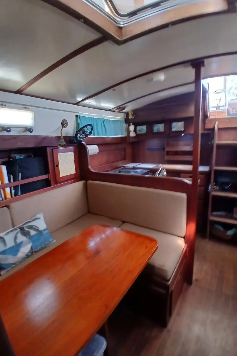 Slide: The Image of Interior of a 1977 Dickerson 41 sailboat with cozy seating and wooden finishes. - 13