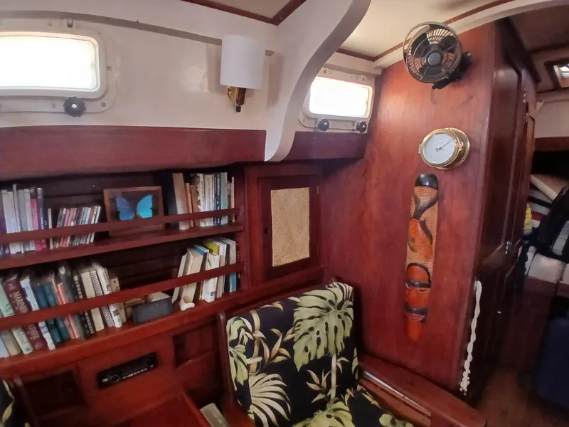 Slide: The Image of 1977 Dickerson 41 yacht interior with bookshelves, tropical-patterned chair, and nautical decor. - 16