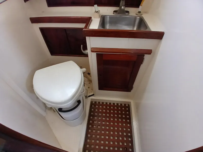 Slide: The Image of Compact bathroom in 1977 Dickerson 41 boat with toilet, sink, and wooden accents. - 20