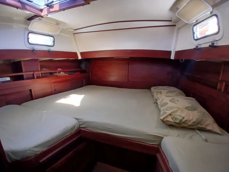 Slide: The Image of Cozy cabin interior of a 1977 Dickerson 41 sailboat with wooden furnishings and a comfortable bed. - 22