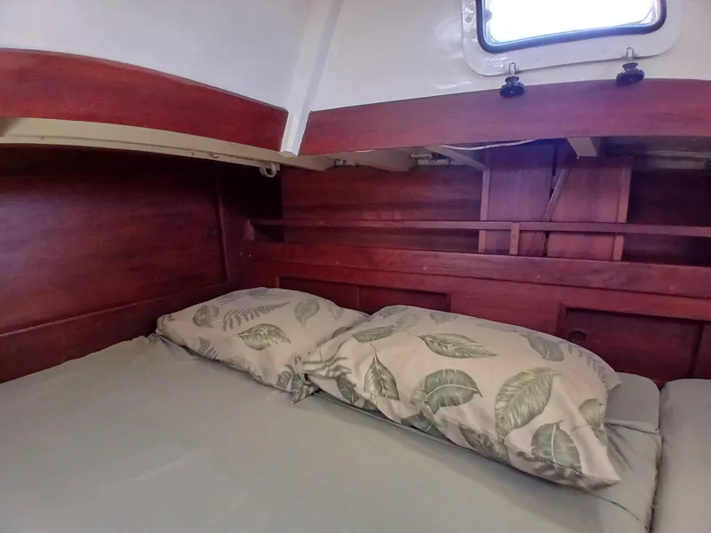 Slide: The Image of Cozy cabin interior of 1977 Dickerson 41 sailboat with leaf-patterned pillows. - 23