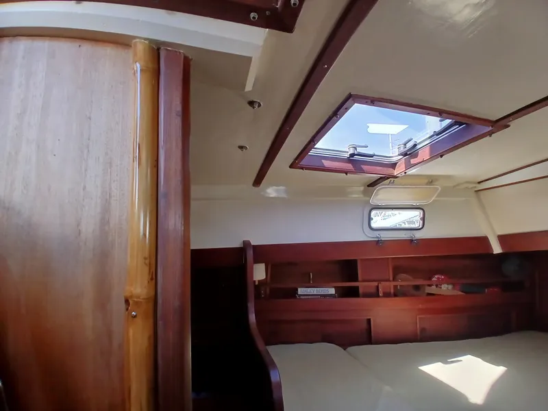 Slide: The Image of Interior of a 1977 Dickerson 41 sailboat with wooden furnishings and a skylight. - 24
