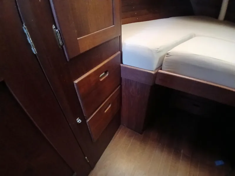Slide: The Image of Interior of 1977 Dickerson 41 sailboat with wooden cabinets and cushioned bed. - 29