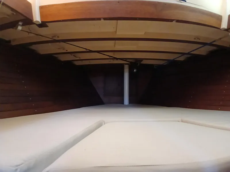 Slide: The Image of Interior cabin view of a 1977 Dickerson 41 sailboat, featuring wooden paneling and cushioned seating. - 30