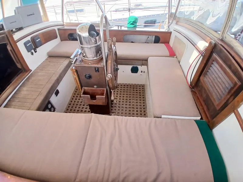 Slide: The Image of 1977 Dickerson 41 sailboat cockpit with wooden accents and cushioned seating. - 40