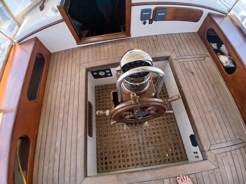 Slide: The Image of Wooden deck of a 1977 Dickerson 41 sailboat with classic steering wheel. - 42