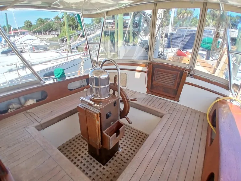 Slide: The Image of 1977 Dickerson 41 sailboat cockpit with wooden flooring and steering wheel. - 43