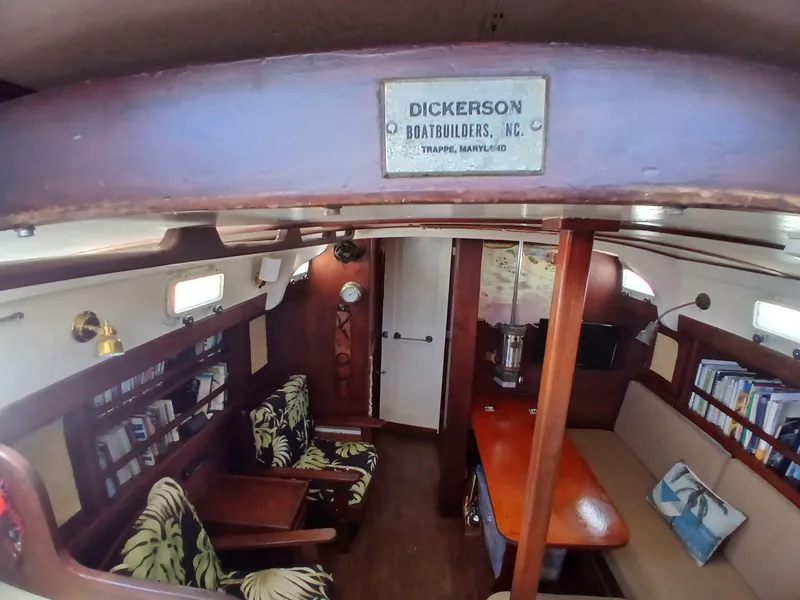 Slide: The Image of Interior of a 1977 Dickerson 41 sailboat with cozy seating and wooden furnishings. - 9
