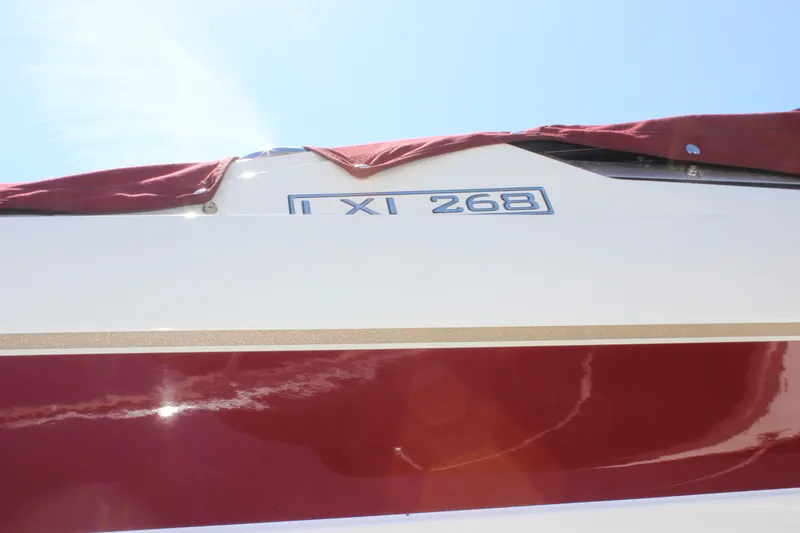 Slide: The Image of 2005 Larson LXi 268 boat with red cover and clear blue sky. - 20