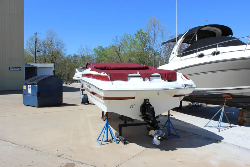 Slide: The Image of 2005 Larson LXi 268 boat on stands, covered, in a marina setting. - 3