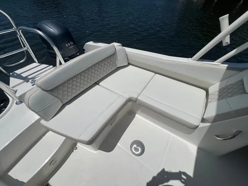 Slide: The Image of 2025 World Cat 230 SD boat with white cushioned seating and water backdrop. - 11