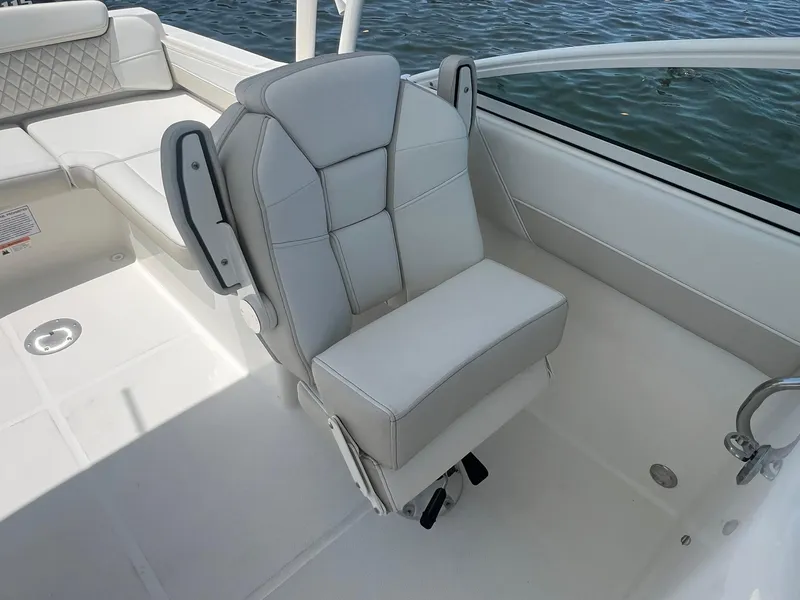 Slide: The Image of 2025 World Cat 230 SD boat interior with cushioned seating and water view. - 14