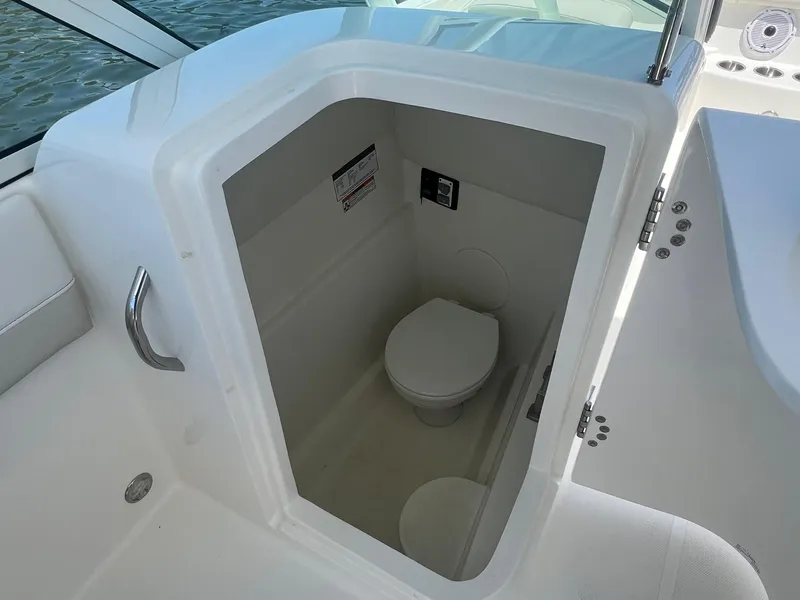 Slide: The Image of 2025 World Cat 230 SD boat interior with compact marine toilet. - 16