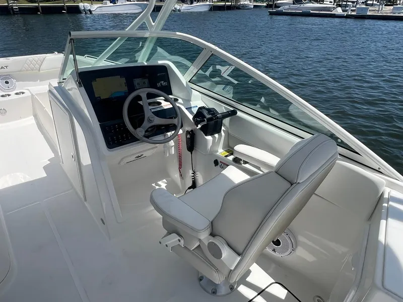 Slide: The Image of 2025 World Cat 230 SD boat cockpit with steering wheel and control panel. - 18