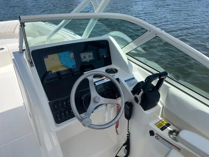 Slide: The Image of 2025 World Cat 230 SD boat dashboard with steering wheel and navigation display. - 19