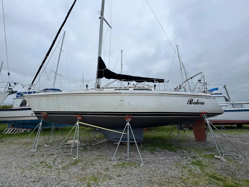 The Image of 1989 Catalina 42 MkII sailboat on stands, named "Bolero," in a boatyard. - 0
