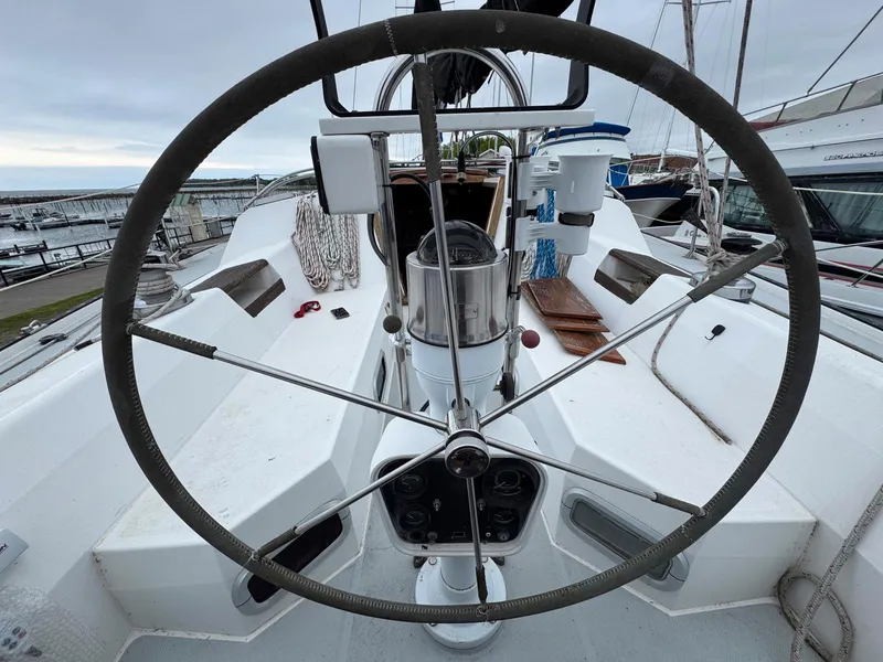 Slide: The Image of Cockpit view of a 1989 Catalina 42 MkII sailboat with steering wheel and navigation instruments. - 12