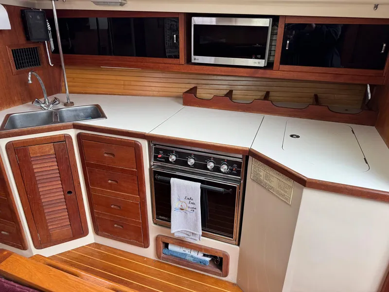 Slide: The Image of Galley kitchen in 1989 Catalina 42 MkII sailboat with stove, sink, and wooden cabinetry. - 19