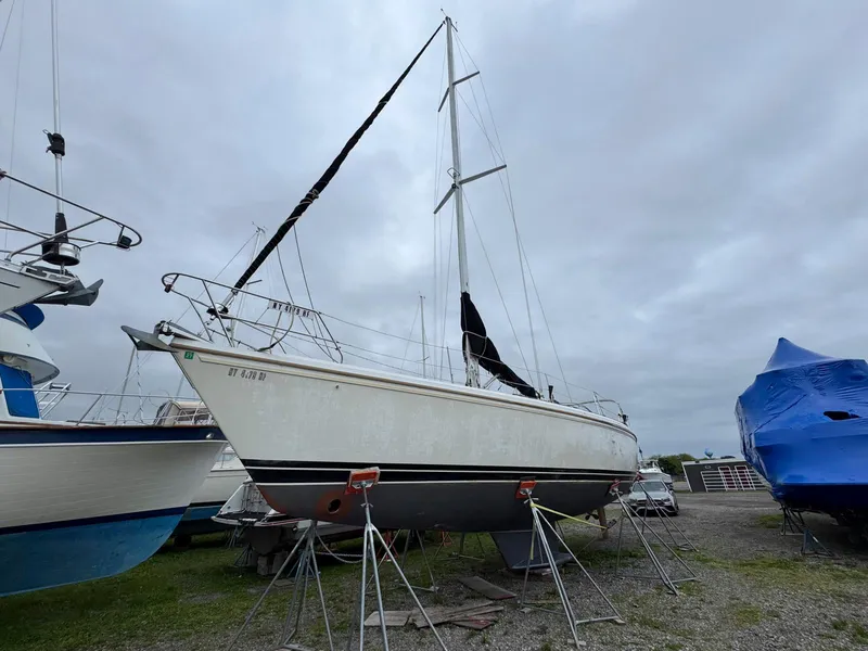 Slide: The Image of 1989 Catalina 42 MkII sailboat on stands, overcast sky, marina setting. - 2