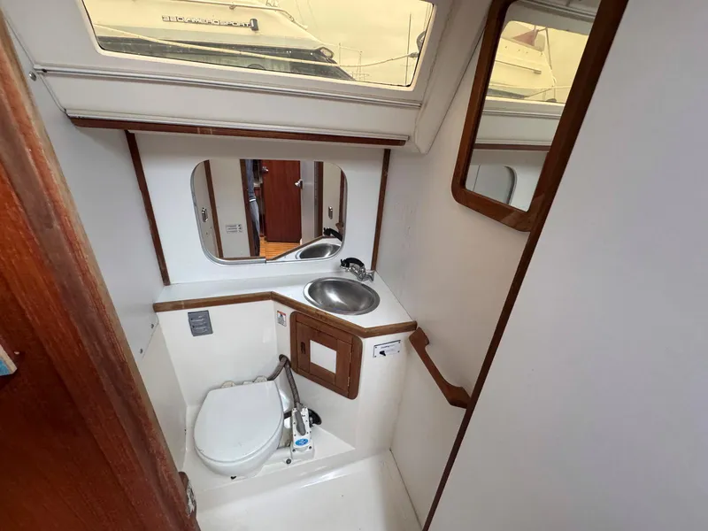 Slide: The Image of 1989 Catalina 42 MkII yacht bathroom with sink, toilet, and mirror. - 27