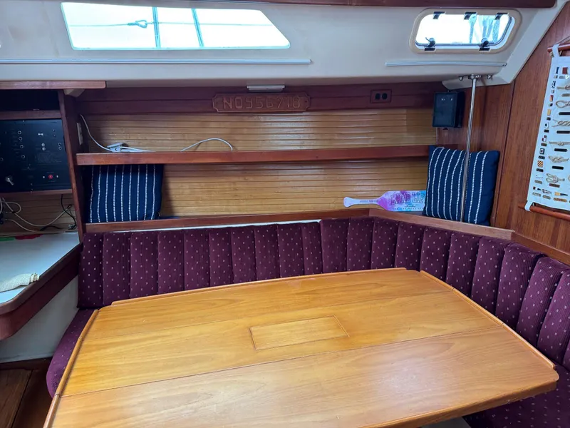 Slide: The Image of Interior of 1989 Catalina 42 MkII sailboat with wooden table and cushioned seating. - 28