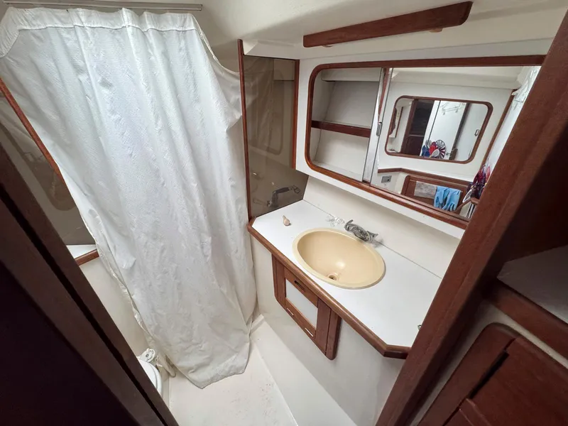 Slide: The Image of Bathroom interior of 1989 Catalina 42 MkII yacht with sink, mirror, and shower curtain. - 30