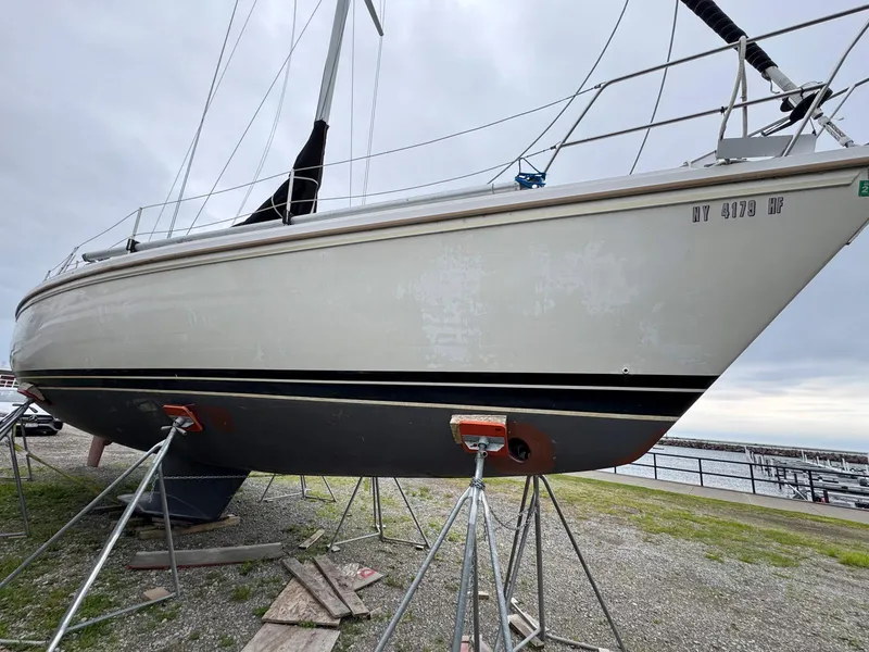 Slide: The Image of 1989 Catalina 42 MkII sailboat on stands, displayed outdoors near a marina. - 8