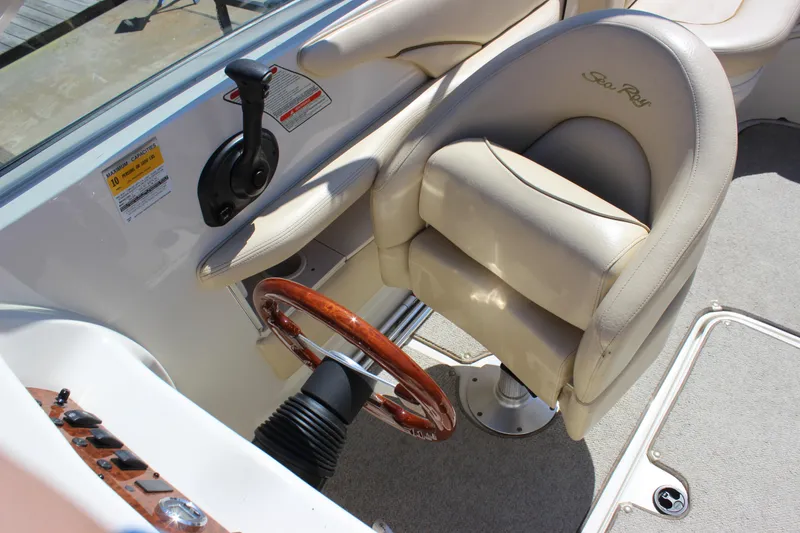 Slide: The Image of 2001 Sea Ray 260 Sundeck helm with beige captain's chair and wooden steering wheel. - 10