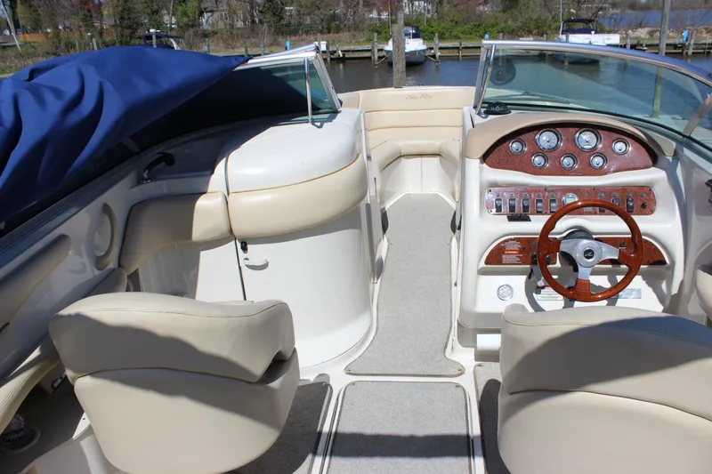 Slide: The Image of Interior view of 2001 Sea Ray 260 Sundeck boat with beige seating and wooden dashboard. - 14