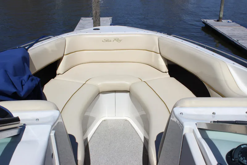 Slide: The Image of 2001 Sea Ray 260 Sundeck boat with beige seating, docked by the water. - 22