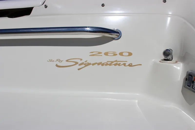 Slide: The Image of 2001 Sea Ray 260 Sundeck boat with "Signature" branding on white hull. - 24
