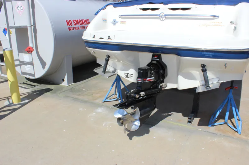 Slide: The Image of 2001 Sea Ray 260 Sundeck boat on stands, with visible outboard motor and fuel tank nearby. - 25