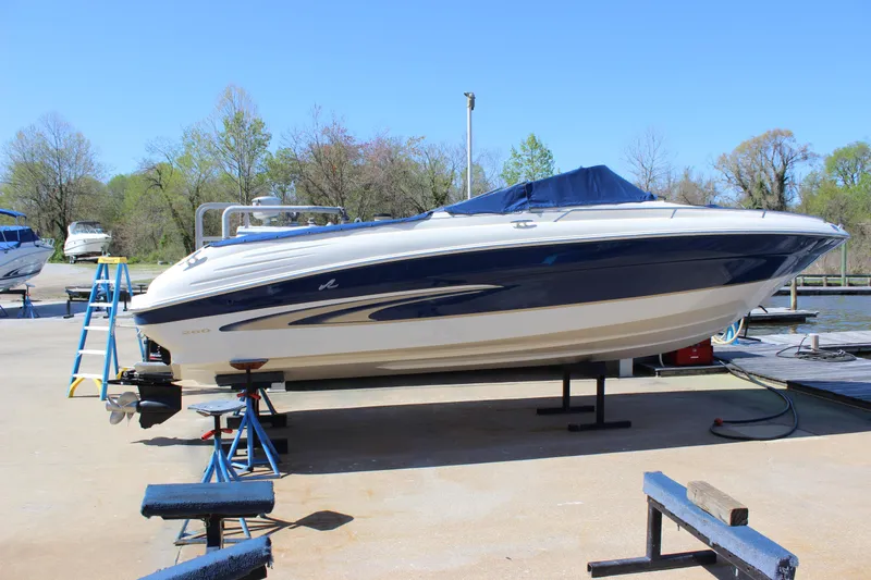 Slide: The Image of 2001 Sea Ray 260 Sundeck boat on dry dock, blue and white, outdoors. - 3