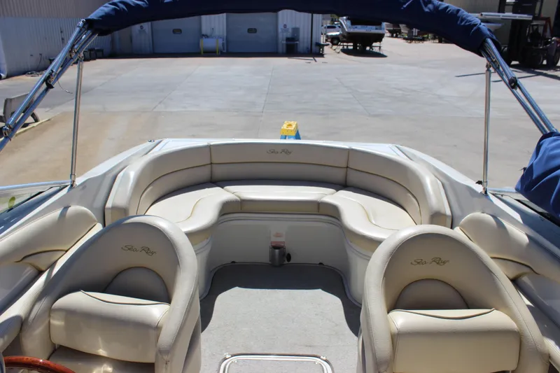 Slide: The Image of 2001 Sea Ray 260 Sundeck boat interior with beige seating and blue canopy. - 7