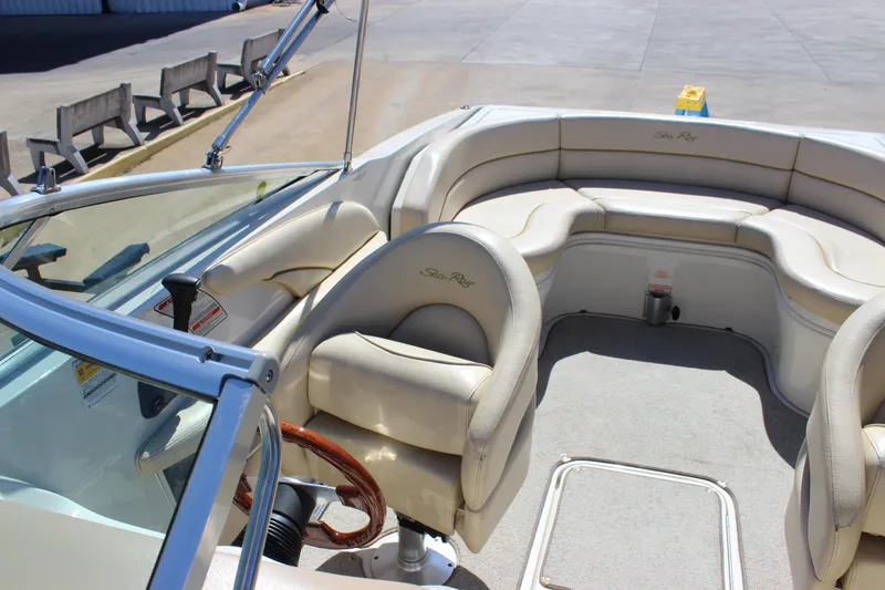 Slide: The Image of 2001 Sea Ray 260 Sundeck boat interior with beige seating and steering wheel. - 8