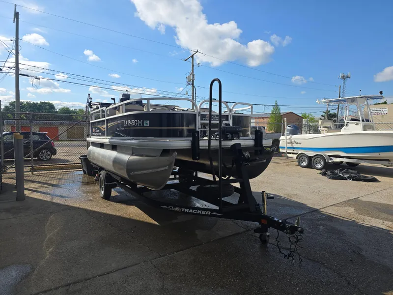 Slide: The Image of 2021 Sun Tracker Bass Buggy 16 DLX pontoon boat on trailer in outdoor lot. - 3