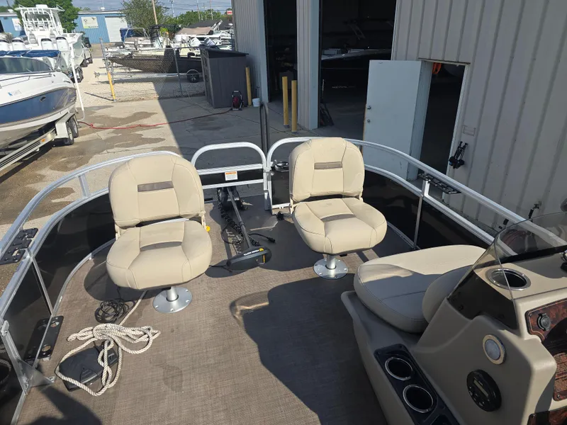 Slide: The Image of 2021 Sun Tracker Bass Buggy 16 DLX pontoon boat with beige seating in a marina setting. - 5