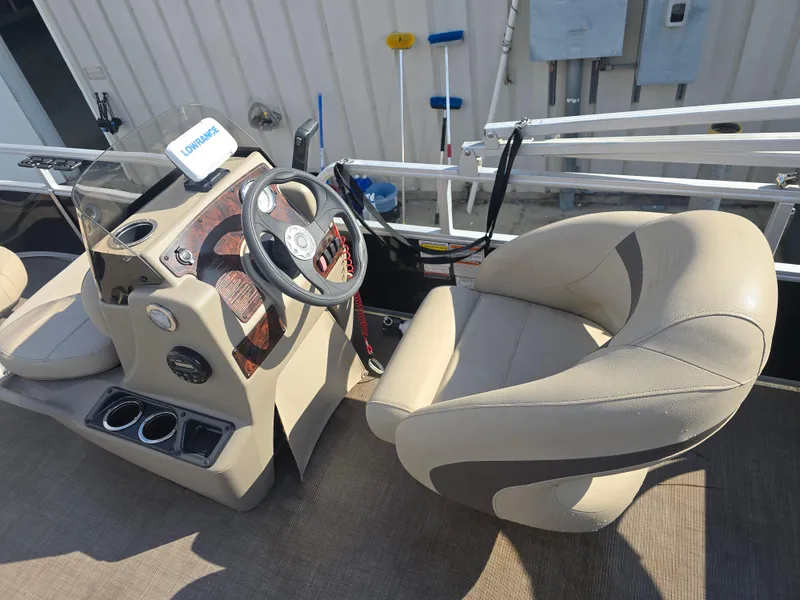 Slide: The Image of 2021 Sun Tracker Bass Buggy 16 DLX boat interior with steering wheel and seating. - 7