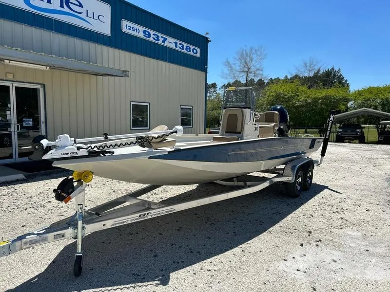 Slide: The Image of 2025 Xpress H22B boat on trailer outside dealership, sunny day. - 2
