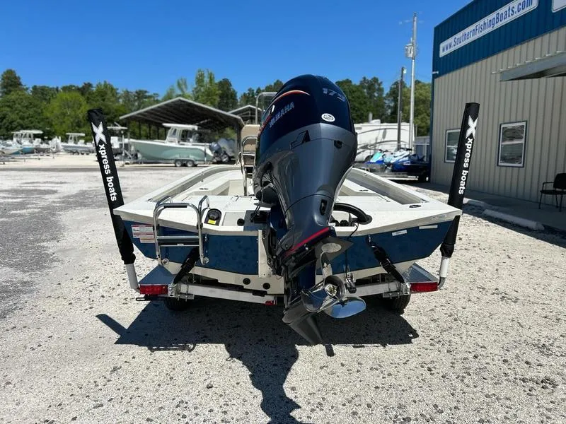 Slide: The Image of 2025 Xpress H22B boat with Yamaha outboard motor, parked at a marina. - 6