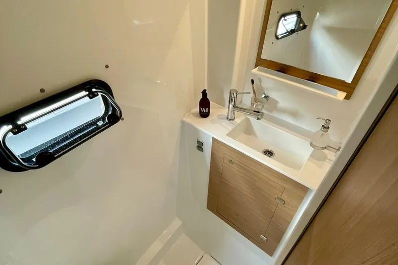 Slide: The Image of Modern bathroom in 2026 Bali CATSPACE yacht with sink, mirror, and porthole window. - 21