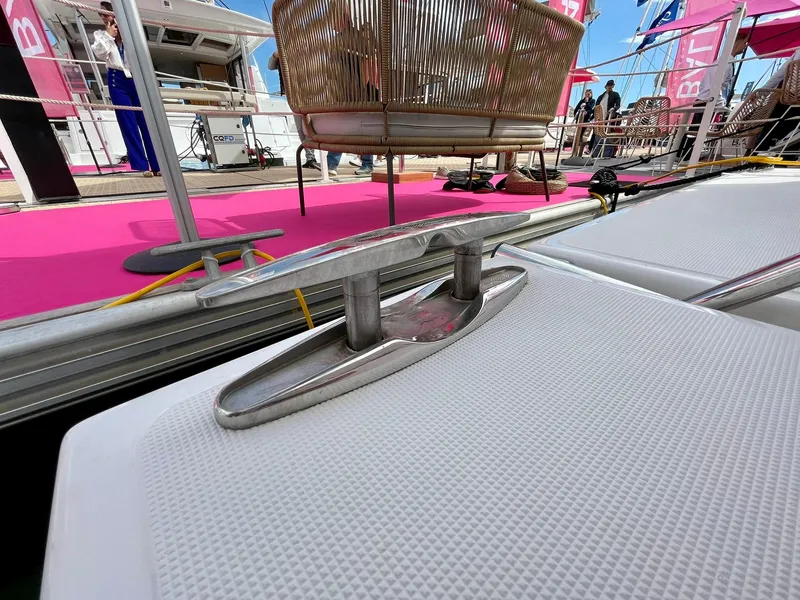 Slide: The Image of Stainless steel cleat on Bali CATSPACE 2026 yacht deck, with pink carpet and wicker chair. - 40