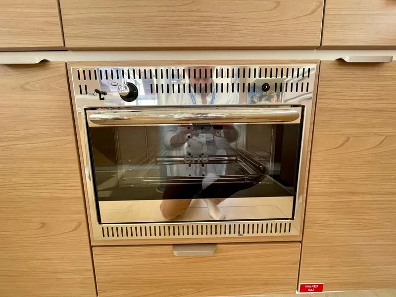 Slide: The Image of Modern oven in wooden cabinetry, Bali CATSPACE 2026 model, with reflective glass door. - 8