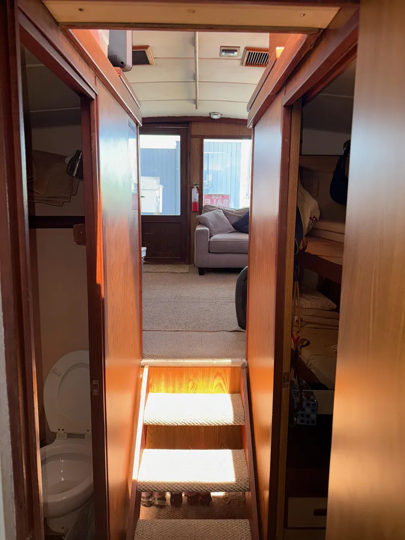 Slide: The Image of Interior view of a 1981 Bertram 38 Convertible yacht, featuring cozy wooden paneling and a comfortable seating area. - 14