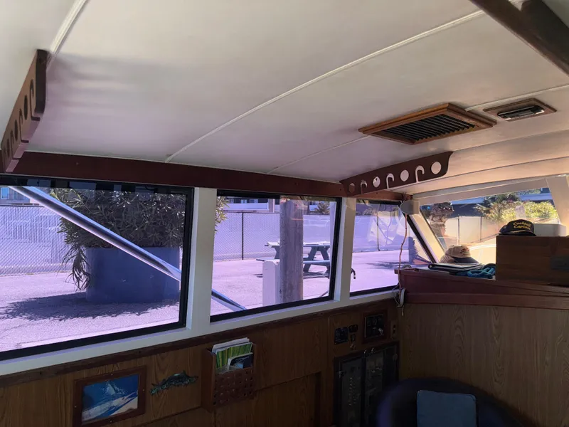 Slide: The Image of Interior view of a 1981 Bertram 38 Convertible boat, showcasing windows and wood paneling. - 18