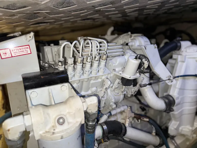 Slide: The Image of Engine compartment of a 1981 Bertram 38 Convertible boat, showcasing mechanical components and piping. - 19