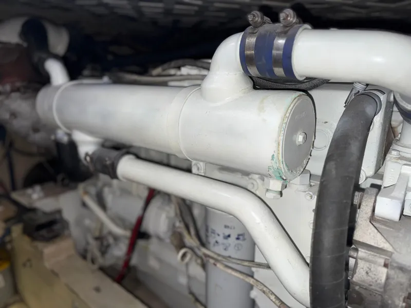 Slide: The Image of Engine compartment of a 1981 Bertram 38 Convertible boat, showcasing pipes and components. - 20