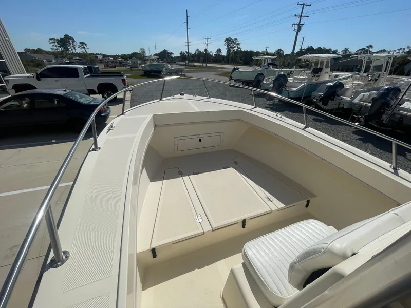 Slide: The Image of 2000 KenCraft Challenger 215 boat deck with seating, parked near other boats. - 10