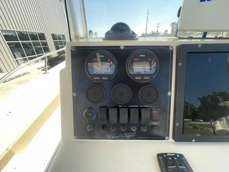 Slide: The Image of Control panel of a 2000 KenCraft Challenger 215 boat with gauges and switches. - 13